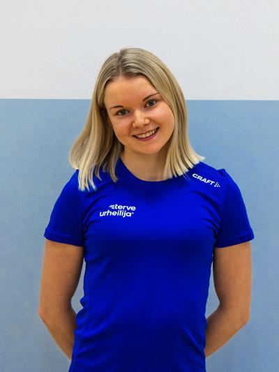 Lähikuva Iida Mustakoskesta sinisessä Terve urheilija -paidassa liikuntasalissa.