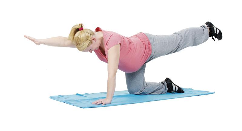 A pregnant woman is doing an exercise for the back muscles.