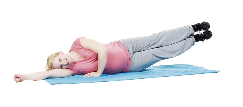 A pregnant woman is doing an exercise for the obliques.