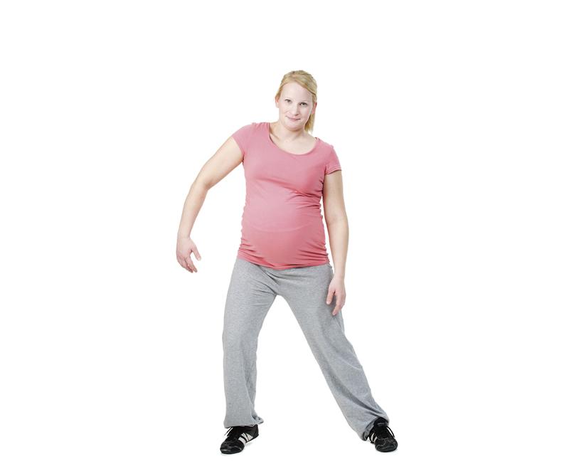 A pregnant woman is doing a step touch exercise.