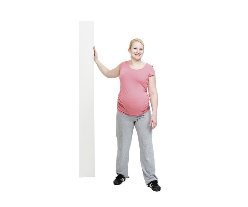A pregnant woman is doing a chest muscle stretch.